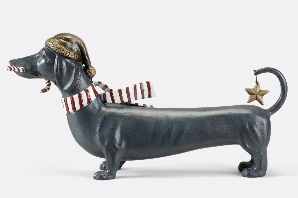 Cast metal holiday dachshund holding candy cane in mouth and wearing a santa hat along with striped scarf 