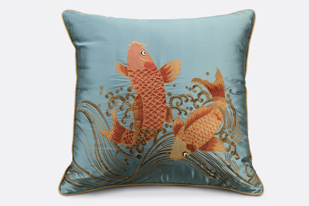 blue satin pillow with embroidered golden fish and wave details 