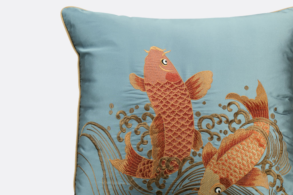 blue satin pillow with embroidered golden fish and wave details