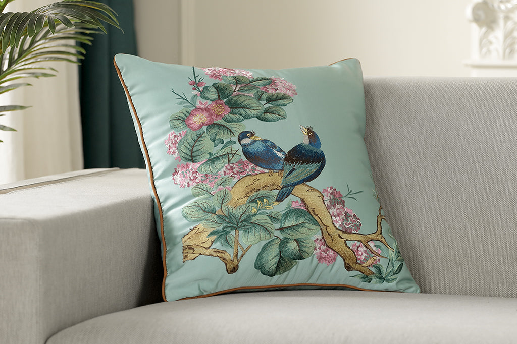 blue satin pillow, embroidered lovebirds seated on branch surrounded with leaves and blooms