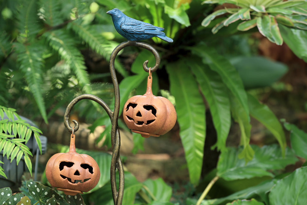 cast metal twisted branch lantern holding two jack o lantern lanterns with black blue raven sitting on branch 