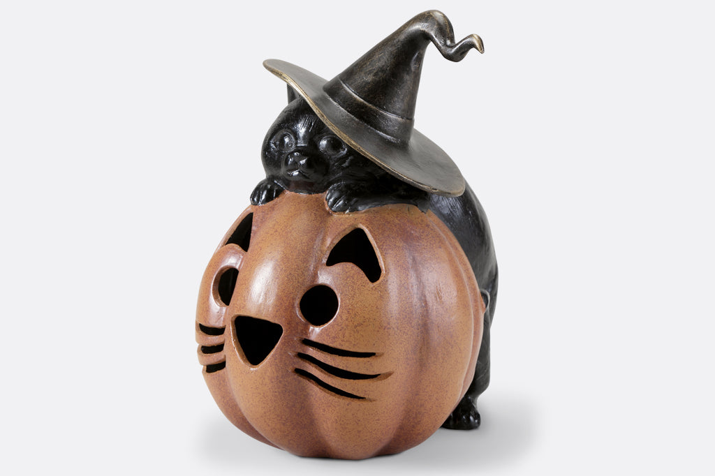 black cat with witch hat hugging a orange cat jack o lantern pumpkin cast metal lantern face left 