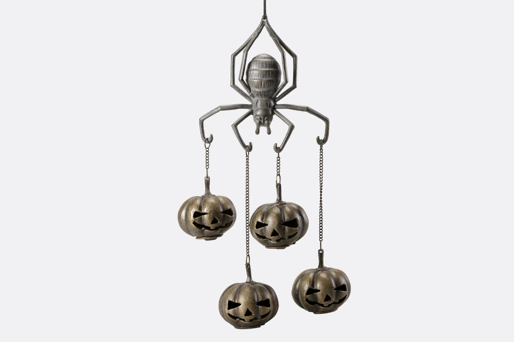 cast metal spider with four jack o lantern pumpkins suspended from spider arms 