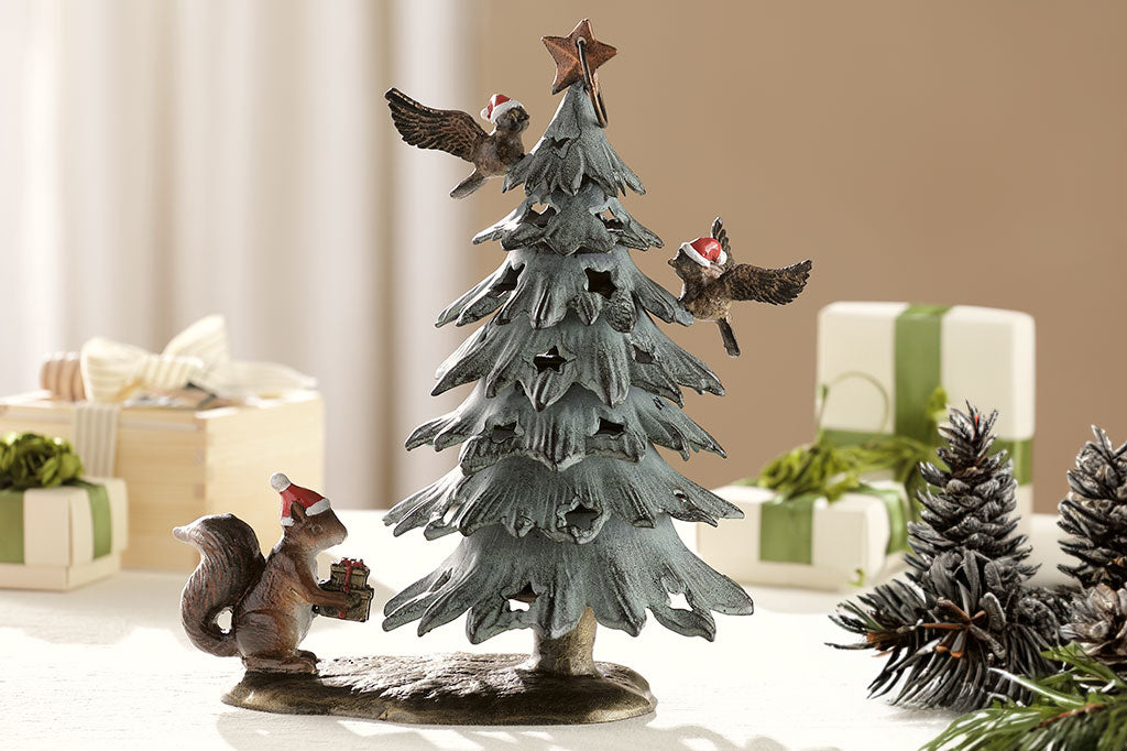 Cast metal christmas tree lantern with birds and squirrel in santa hats shown on table with gifts and pinecones