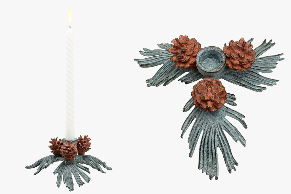 side view and top view of the Conifer Charm Taper candle holder - taper candle holder shaped like pineneedle cluster with 3 pinecones shown in front of Christmas tree