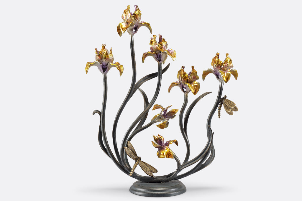 cast metal iris taper candelabra holding five tapers, irises are a delicate blend of yellow with purple. Dragonfly detailing on stem of flowers 