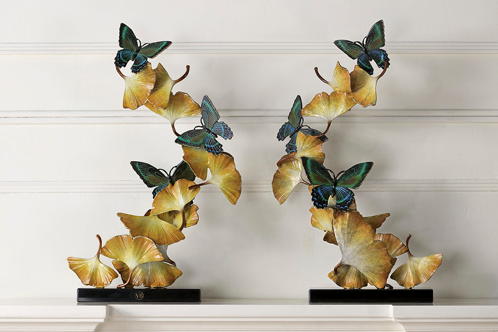 Limited Edition sculpture features fluttering ginkgo leaves and exquisitely finished butterflies, spiraling upwards from a marble base. Two shown on a white mantel against white wall