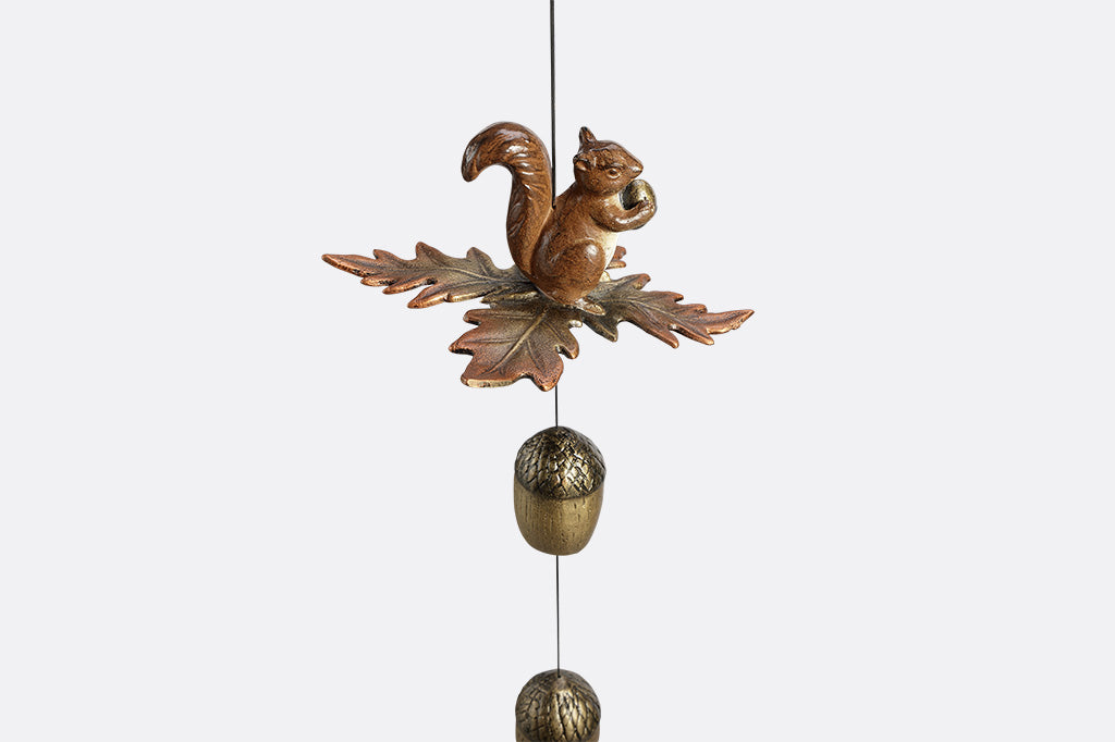 Decorative wind art with a squirrel and acorn design on a white background