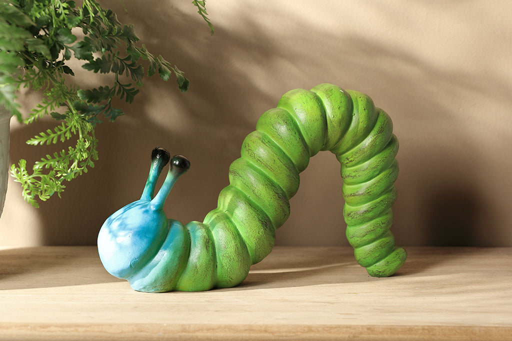 cast metal caterpillar with two antenna, colored in a lime green fading to a sky blue towards the head of caterpillar  