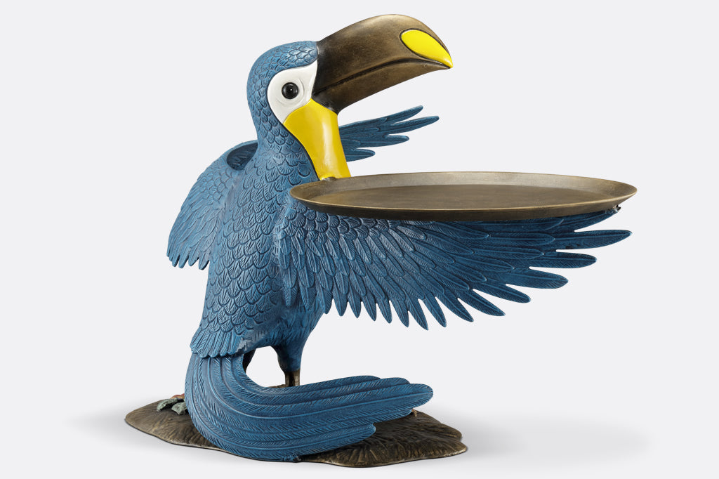 cast metal toucan holding a serving tray on wing, blue and yellow toucan face right displaying back and side wings with feather detailing 