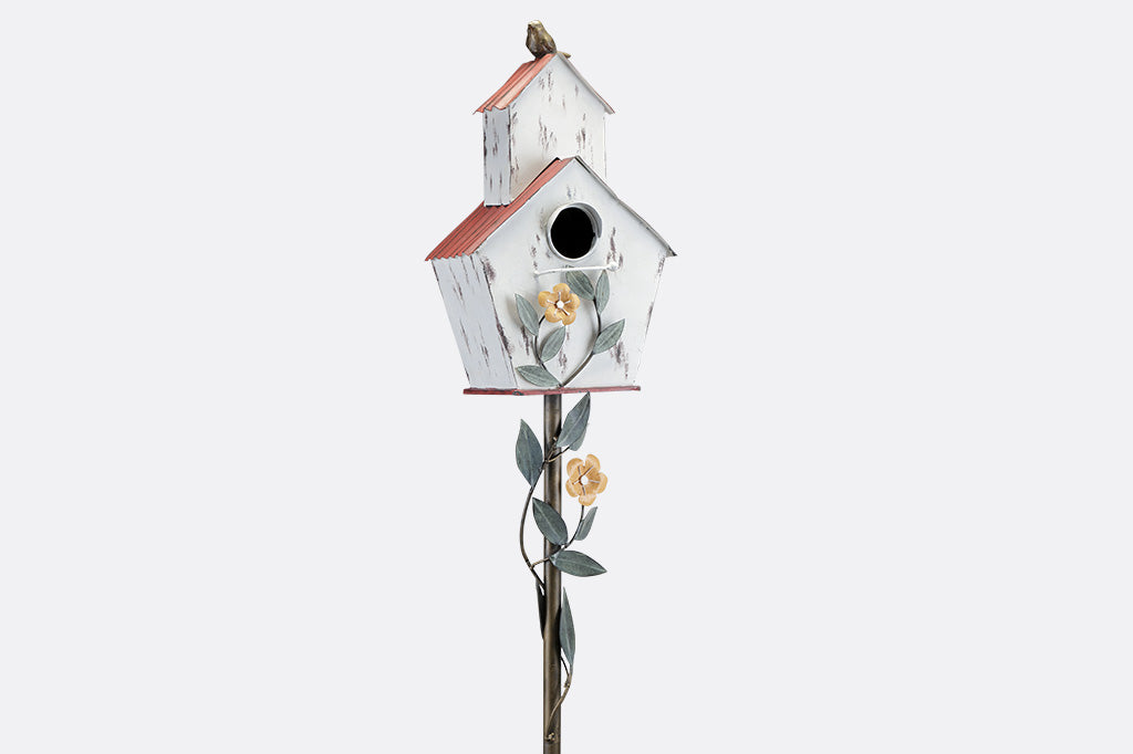 Decorative Iron birdhouse on stake, looks like rustic barn, accented with vining flowers and bird on roof