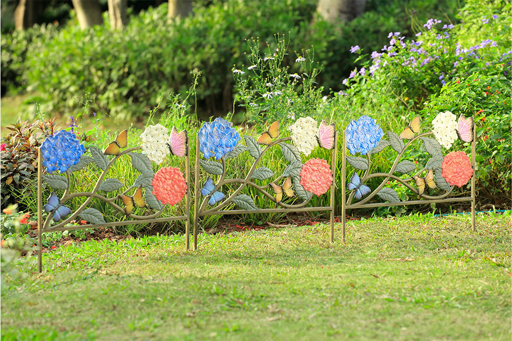 3 garden edge frames made from cast metal; shown in garden. Each has a butterfly and hydrangea motif