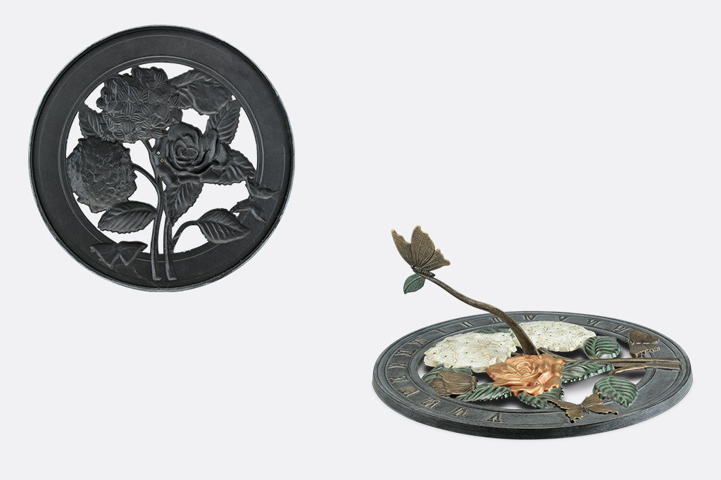 Back and alternate view of a sundial of cast metal with roman numerals, and a butterfly on the shadow-casting gnomon. Features butterflies, hydrangea, and roses.