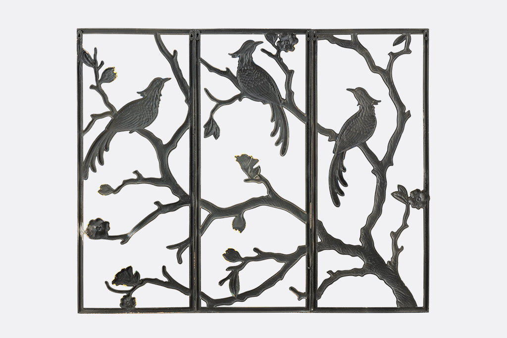 Decorative wall art with birds and branches on a white background
