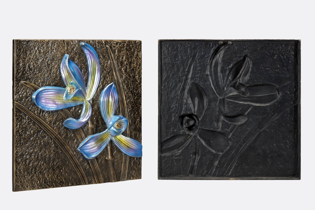 Decorative wall tile with metallic orchid motifs in blue, side and back views