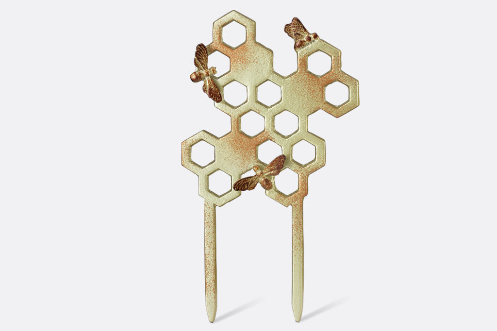 cast metal honeycomb shaped planter trellis with bee detailing. In a metallic golden color with honey colored speckling for depth 