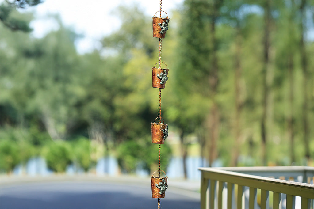 Crafted with 8 detachable rain cups, this chain guides water from gutters to the ground with a charming frog and lily pad motif. Shown in outdoor deck setting in the woods