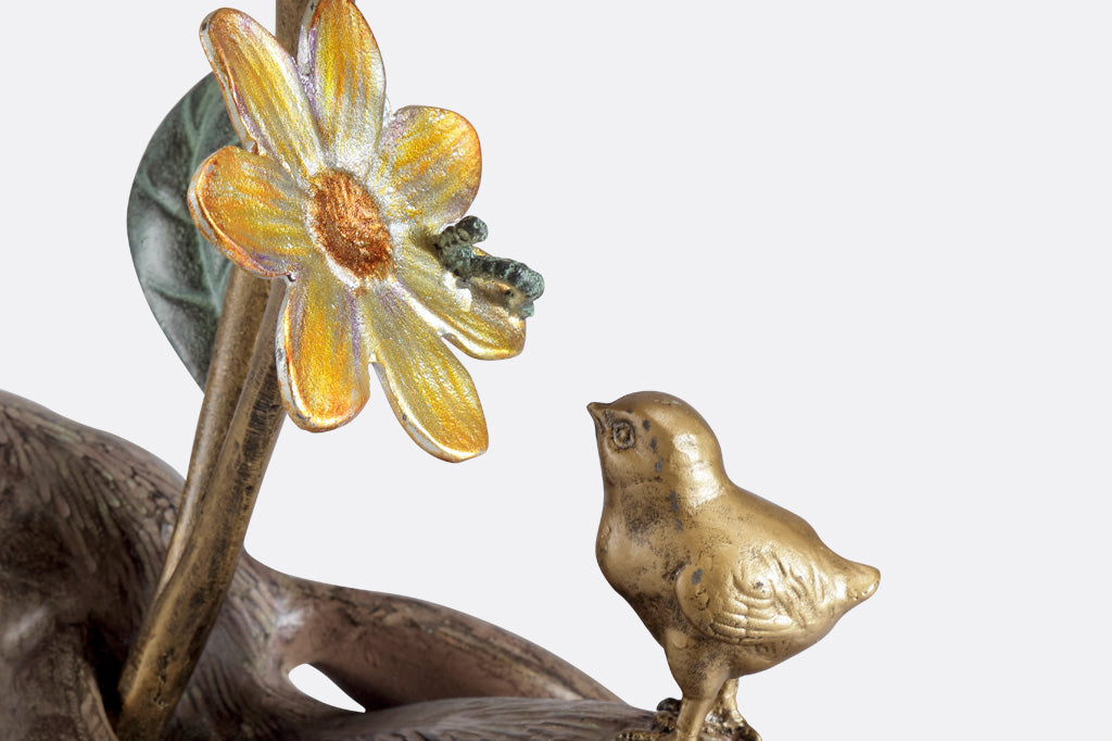 closeup view of sculpted chick, caterpiller and blossom