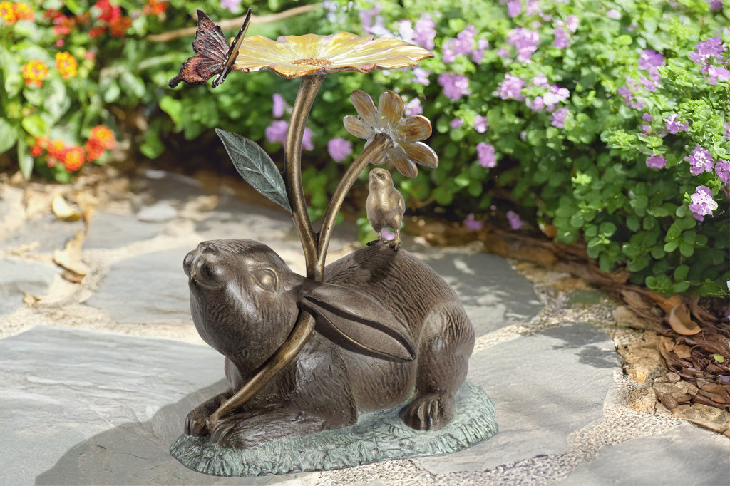 rabbit sculpture and birdbath/birdfeeder. A rabbit holds a blossom, surrounded by a chick, butterfly, and caterpillar