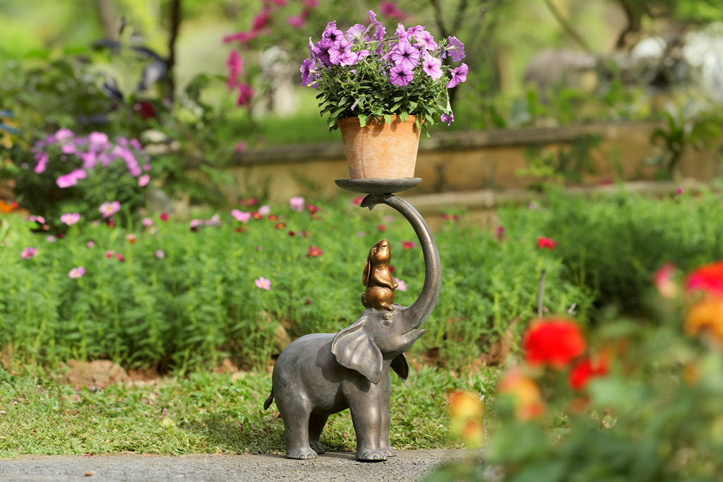 Garden Sculpture Plant Stand shows rabbit sitting on elephant's head, whose trunk holds a plant tray