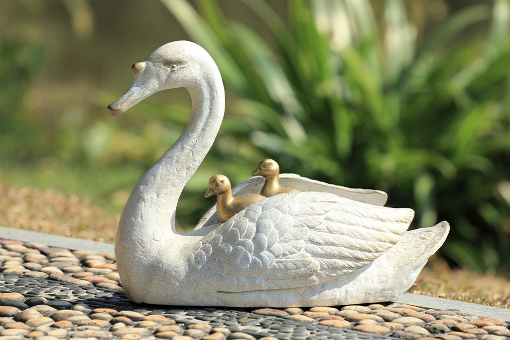 cast metal garden sculpture of mama swan with two baby cygnets nestled on her back 