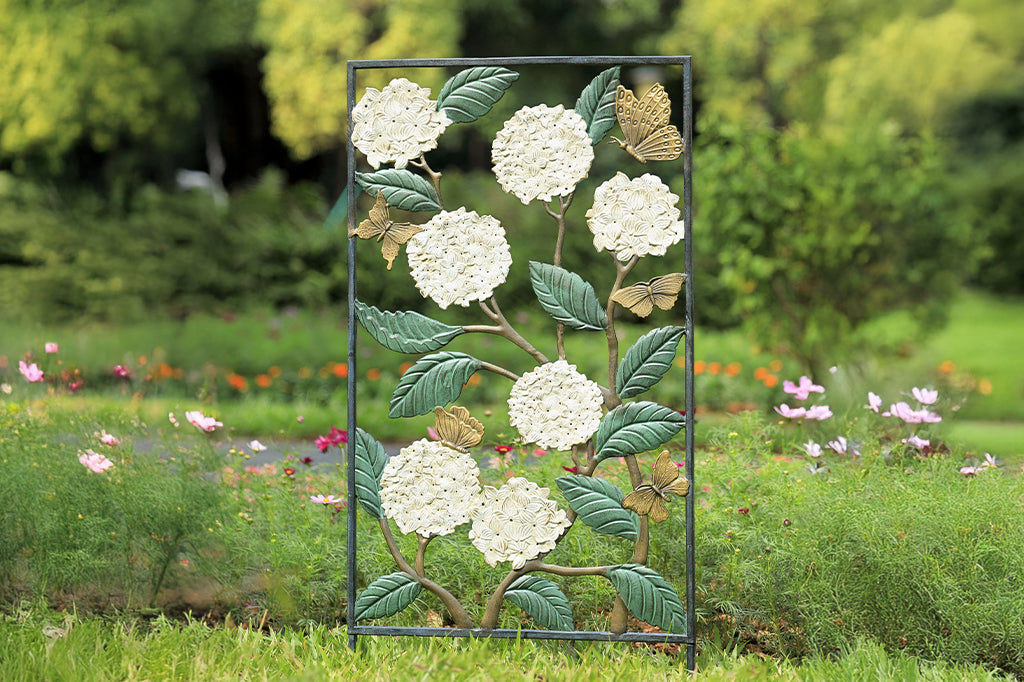 white hydrangea with fluttering butterfly garden trellis set in garden 