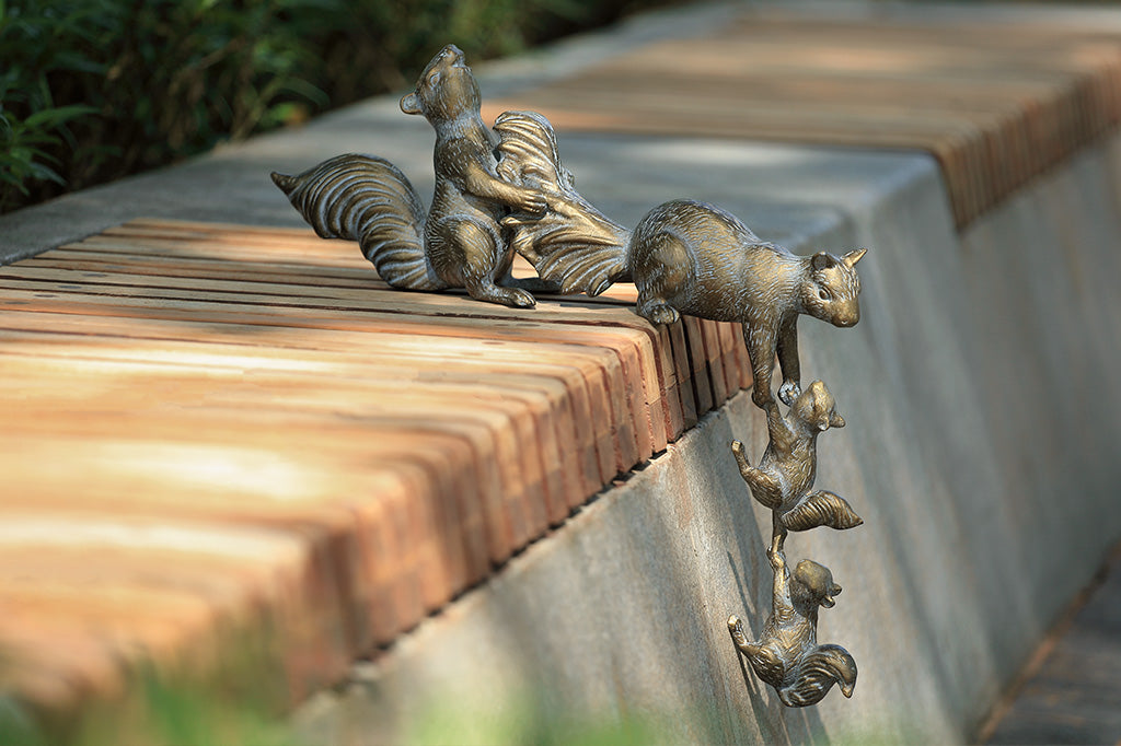 A sculpture of 4 squirrels lifting themselves up a corner.