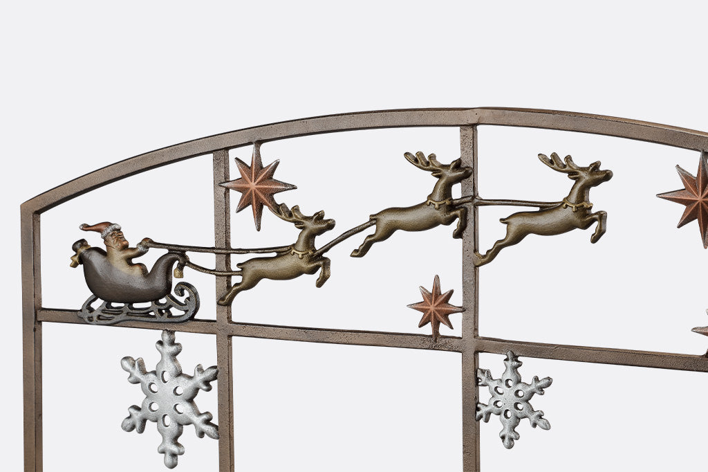 close up detail of cast metal santa and reindeer on a decorative fireplace screen