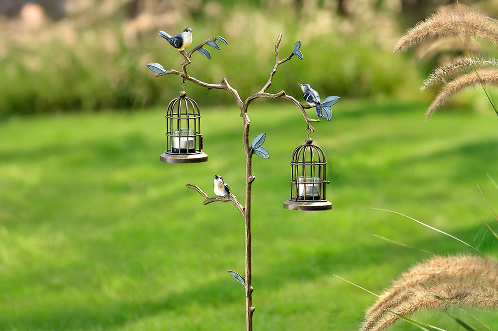 cast metal branch with birds and birdcages housing candles 