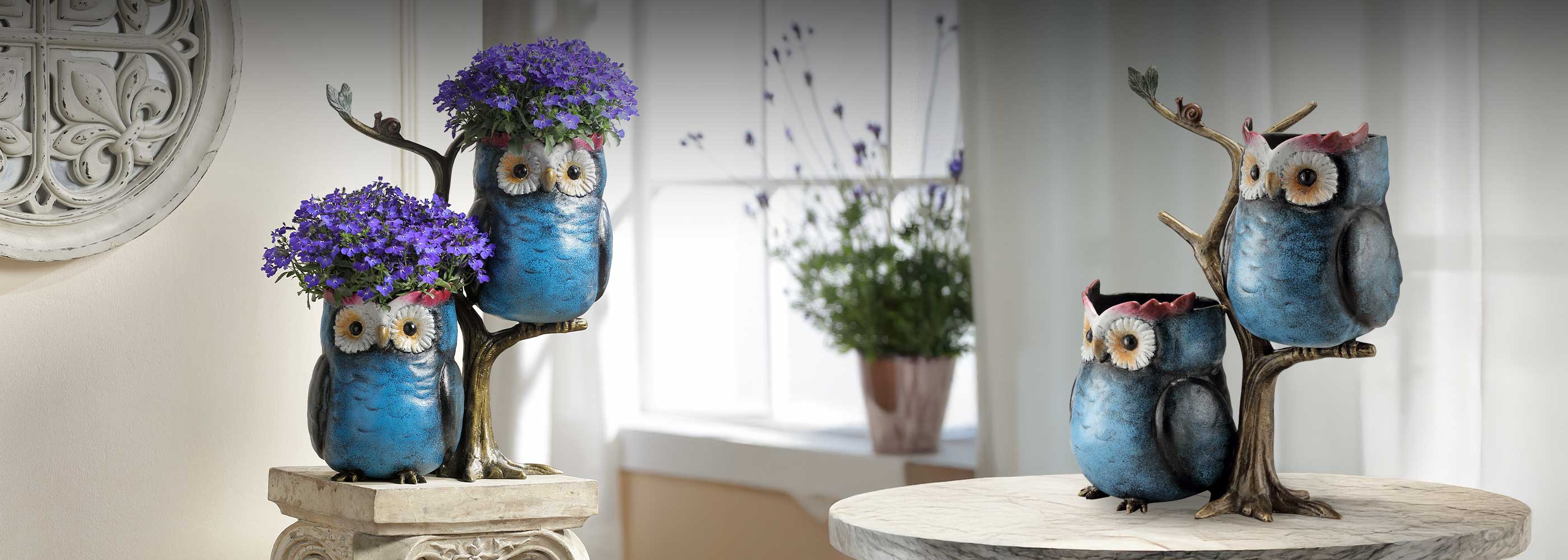 Decorative owl statues with flowers on a table