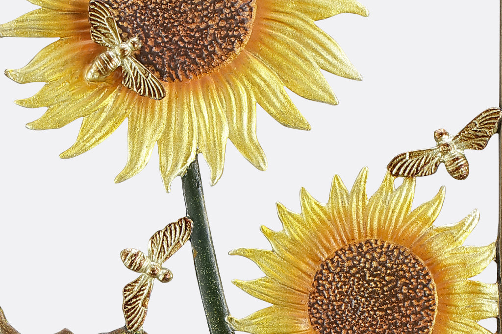detail view of golden sunflowers with shiny bees buzzing around cast metal trellis