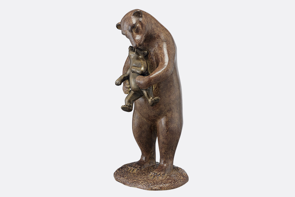 The side profile of a brown sculpture of a bear holding a cub to hug them.