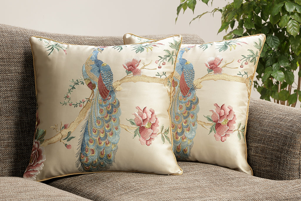 embroidered peacock on branch with peony flowers on champagne satin pillow set on couch 