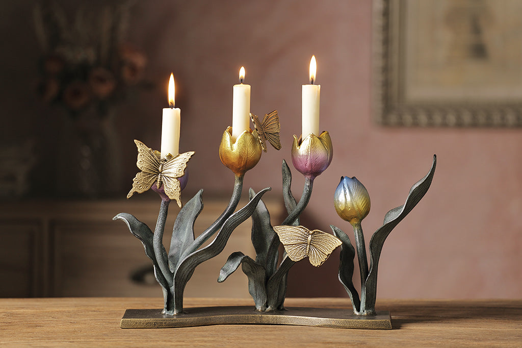 A candleholder sculpture of 4 gold, red, pink, and blue colored tulips with golden butterflies.
