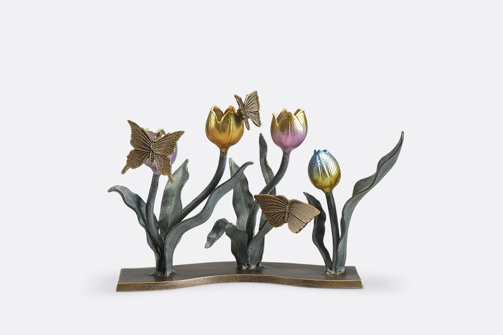A candleholder sculpture of 4 gold, red, pink, and blue colored tulips with golden butterflies.