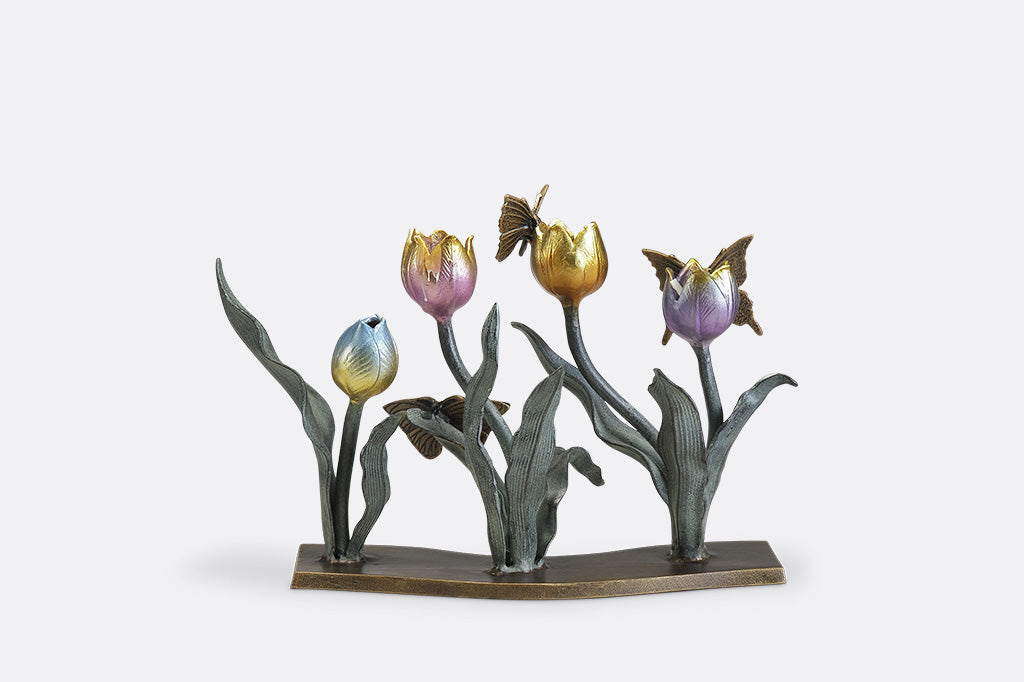 A candleholder sculpture of 4 gold, red, pink, and blue colored tulips with golden butterflies.