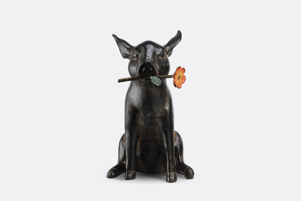 Pig sculpture with a flower in its mouth 