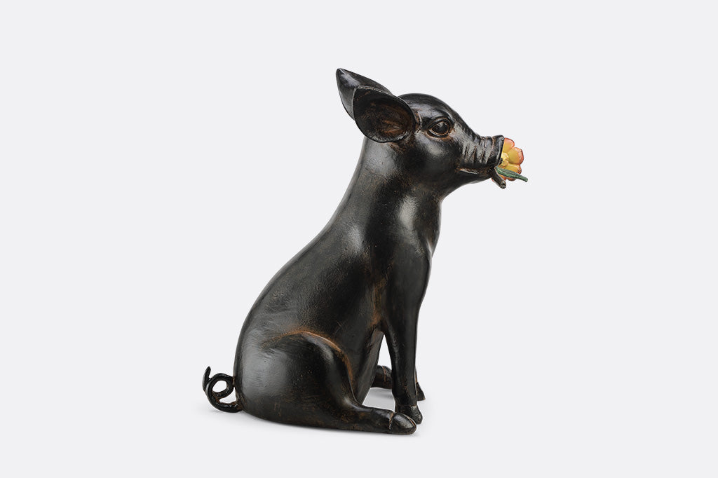 Pig sculpture with a flower in its mouth 