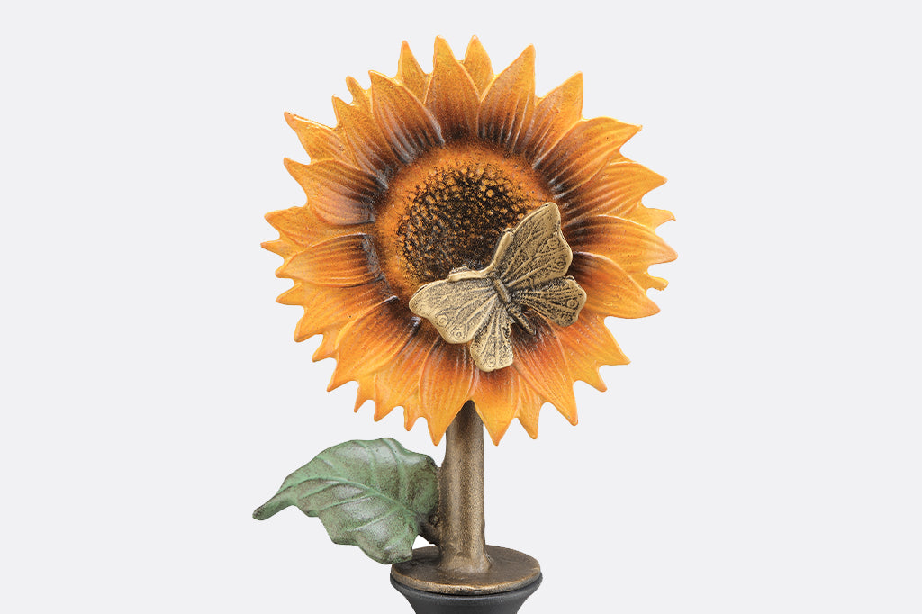 close up view of yellow sunflower with butterfly in center of flower 
