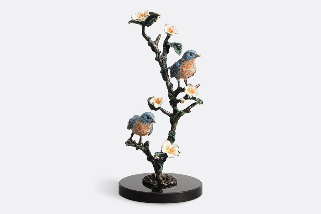Decorative figurine of birds on a branch with flowers on a white background