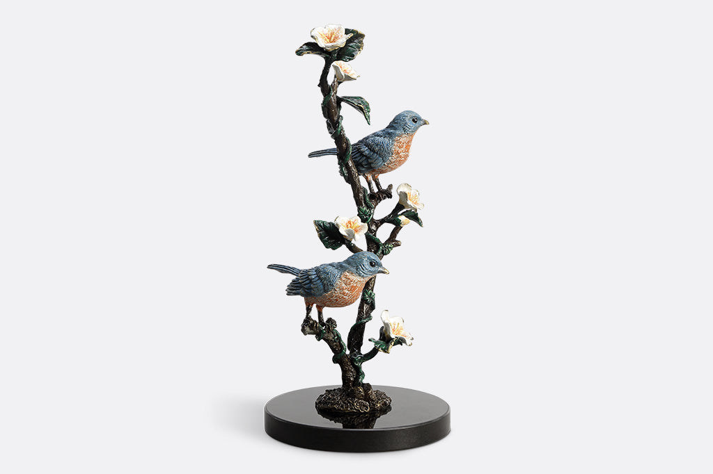 Decorative figurine of birds on a branch with flowers on a white background