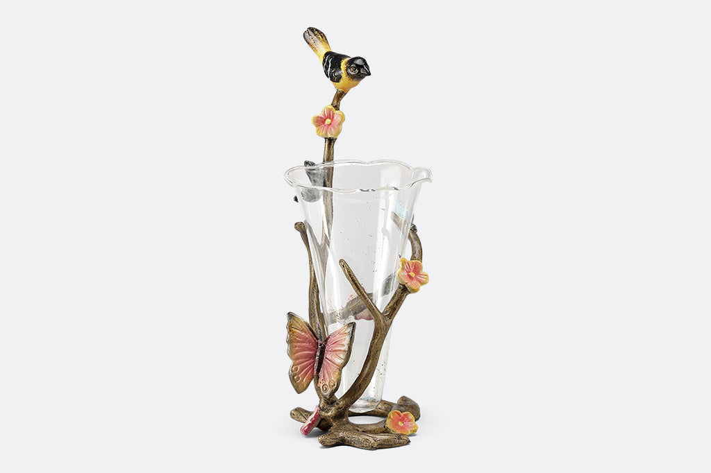A sculpture vase of a bird and butterfly sat on a branch.