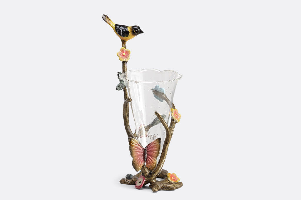 A sculpture vase of a bird and butterfly sat on a branch.