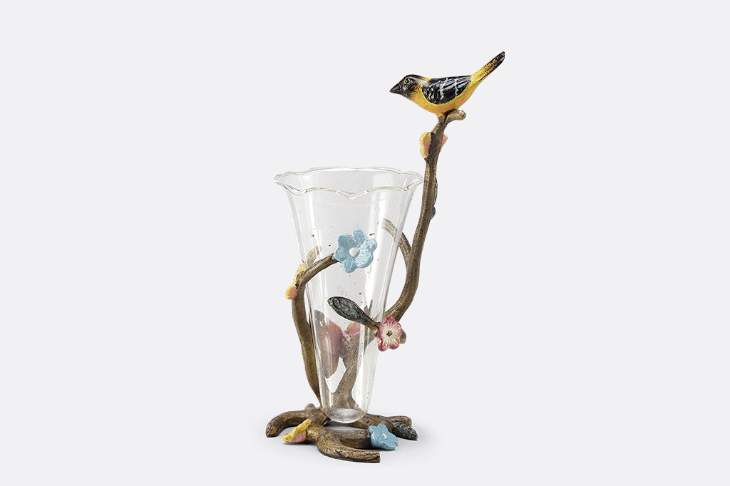 A sculpture vase of a bird and butterfly sat on a branch.
