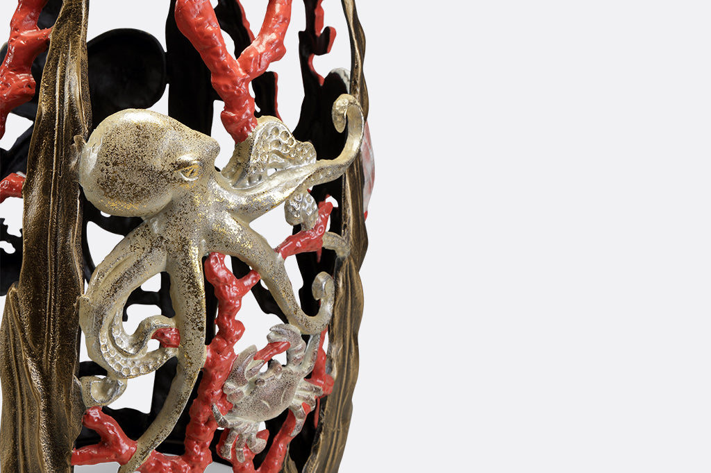 Garden stool featuring pink corals, an octopus, seashells, and crabs.