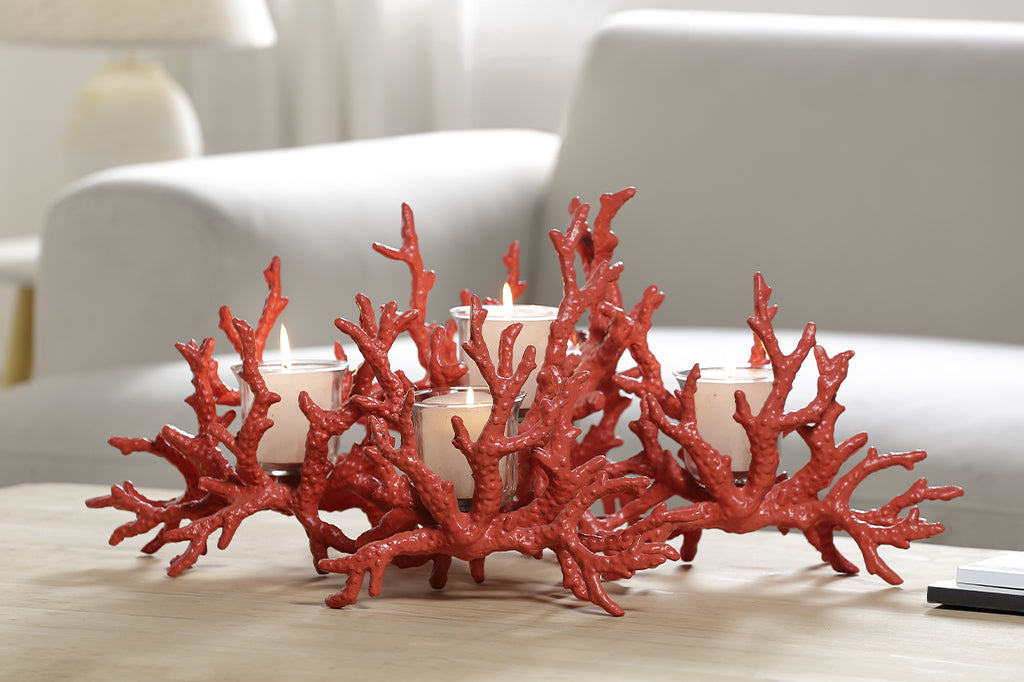 A candleholder in the shape of a pink coral reef that holds votive candles.