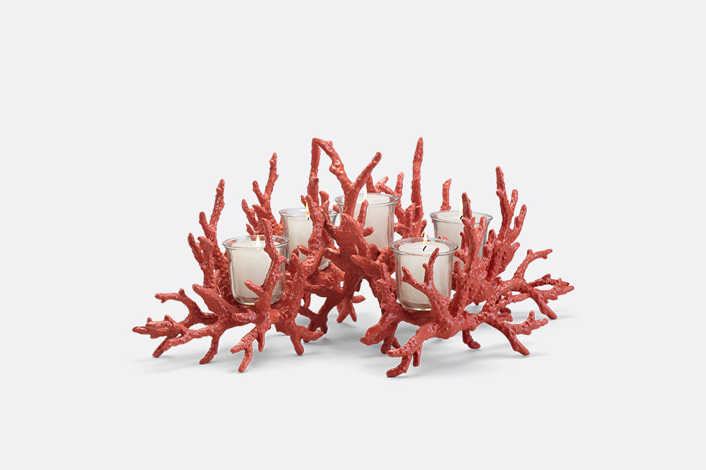 A candleholder in the shape of a pink coral reef that holds votive candles.