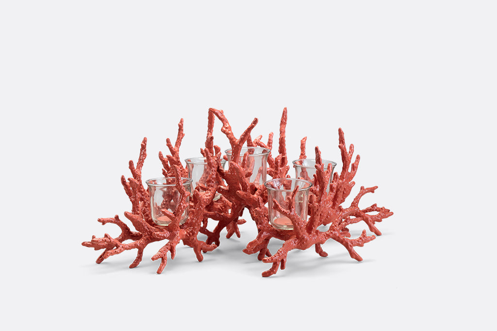 A candleholder in the shape of a pink coral reef that holds votive candles.