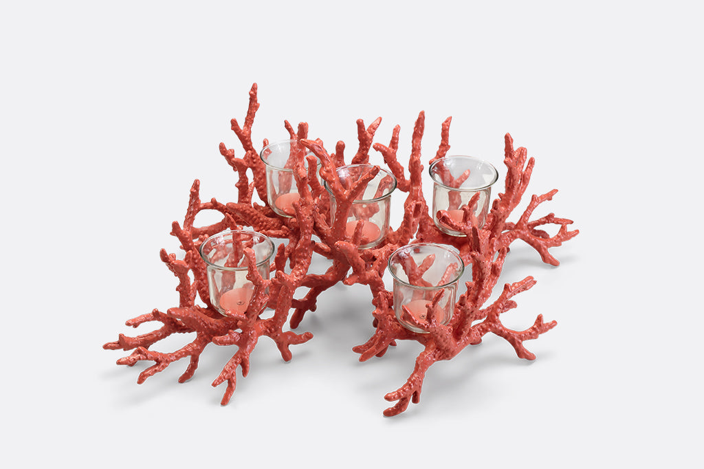 A candleholder in the shape of a pink coral reef that holds votive candles.