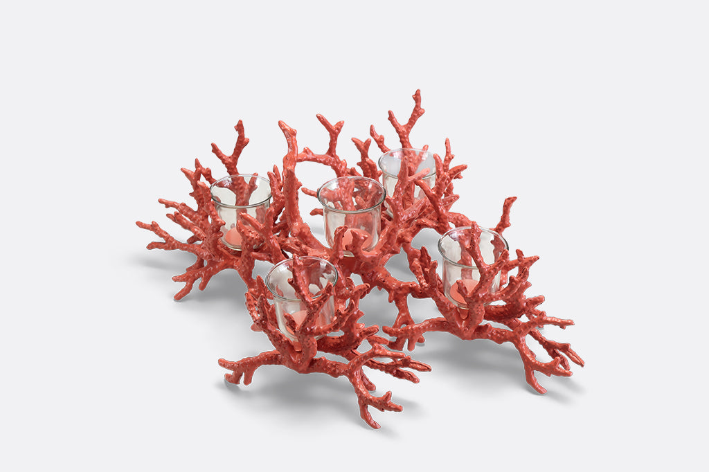 A candleholder in the shape of a pink coral reef that holds votive candles.